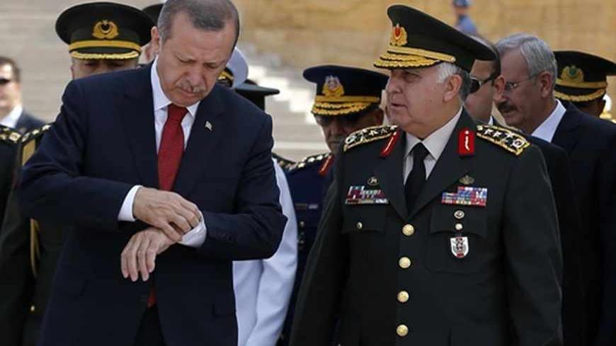 Turkey's Prime Minister Tayyip Erdogan (L) checks his watch as he attends a wreath-laying ceremony with Chief of Staff General Necdet Ozel (R) at the mausoleum of Mustafa Kemal Ataturk, founder of modern Turkey, in Ankara August 1, 2013. REUTERS/Umit Bektas (TURKEY - Tags: MILITARY POLITICS) - RTX126WW