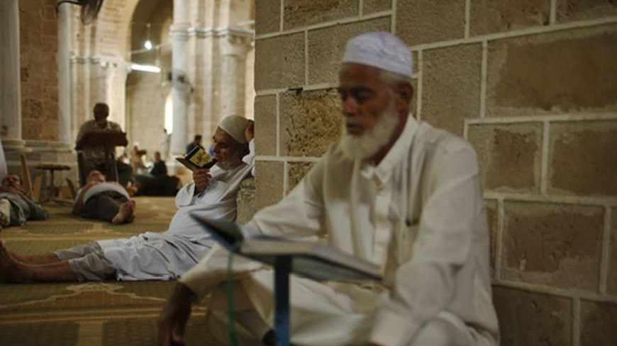 Palestinian men recite the Koran at al-Omari mosque in Gaza City, during the first day of the holy fasting month of Ramadan, July 10, 2013. REUTERS/Mohammed Salem (GAZA - Tags: RELIGION SOCIETY) - RTX11ILU