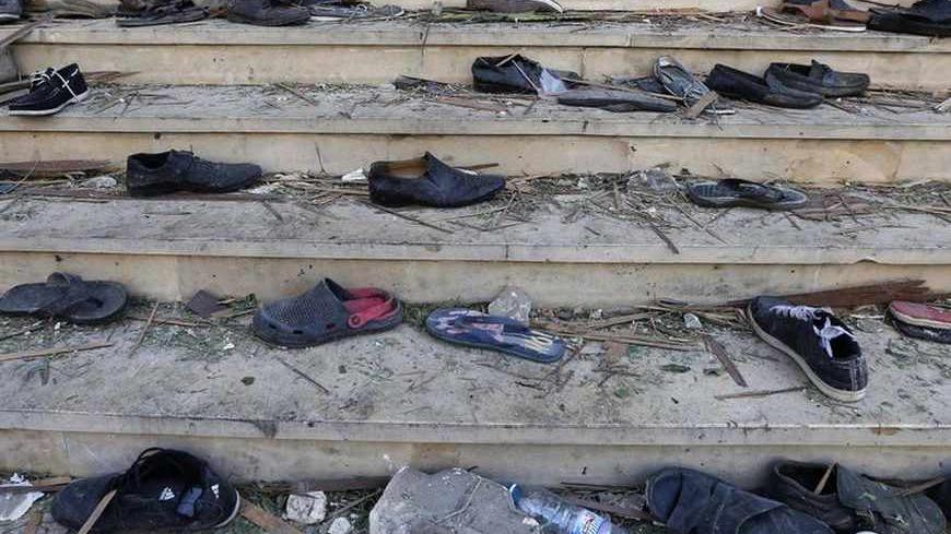 Shoes and slippers left by Muslims who were attending Friday prayers are seen at one of two mosques hit by explosions in Lebanon's northern city of Tripoli, August 23, 2013. Twin explosions outside the two mosques killed at least 27 people and wounded hundreds in apparently coordinated attacks in the northern Lebanese city of Tripoli on Friday, a senior health official and witnesses said. REUTERS/Mohamed Azakir (LEBANON - Tags: POLITICS CIVIL UNREST) - RTX12UE3