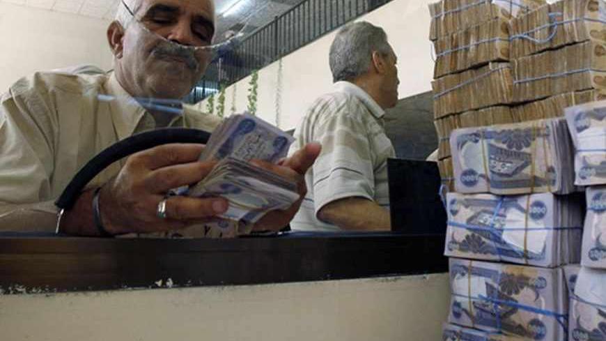 A client counts his money at Al-Rafidain bank in BaghdadJune 21, 2009. Total bank deposits in February -- the latest figures  available -- jumped by half to 36.6 trillion Iraqi dinars ($31 billion) from a year before, and loans surged 65 percent to 5.1 trillion dinars over the same period, central bank data show. 
 To match feature IRAQ/BANKS   REUTERS/Bassim Shati (IRAQ CONFLICT BUSINESS) - RTR2559B