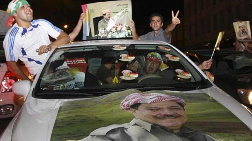 Iraqi Kurdish residents hold up a picture of Kurdish President  Masoud Barazani as they celebrate after elections in Arbil, 310 km (193 miles) north of Baghdad July 26, 2009. Preliminary results of elections in Iraqi Kurdistan, widely expected to keep two ruling parties in power despite an unprecedented opposition challenge, will be announced on Monday, Iraq's electoral commission said. Picture taken July 26, 2009. REUTERS/Azad Lashkari (IRAQ POLITICS ELECTIONS) - RTR263E6
