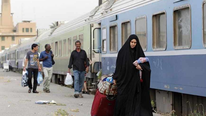 A passenger walks beside a train in a train station in Baghdad May 6, 2013. Iraq's infrastructure is dilapidated after decades of war, sanctions and economic decline. In a country where piles of rubble and incomplete buildings are commonplace, almost every sector needs investment, including electricity and the sewage system. But the country is laying plans to rebuild its historic railways and become a transit hub for goods that would be shipped from Asia to Iraq’s neighbours and beyond. Iraq's railways date