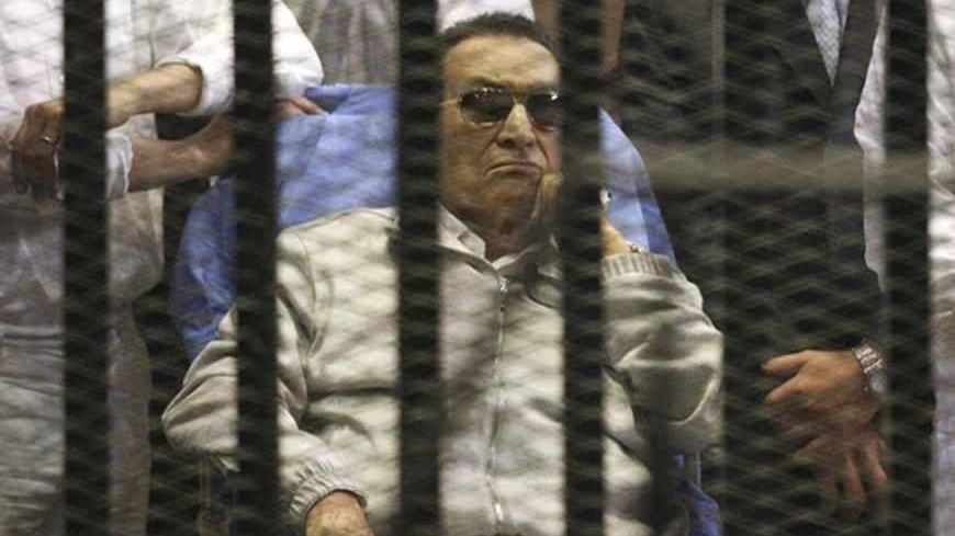 Egypt's ousted President Hosni Mubarak sits inside a dock at the police academy on the outskirts of Cairo April 15, 2013. Mubarak will stay in detention despite a judge ordering his release on bail pending a retrial over charges in complicity in the murder of protesters because he still faces other charges, court officials said on Monday. REUTERS/Stringer (EGYPT - Tags: POLITICS CRIME LAW) - RTXYMLH