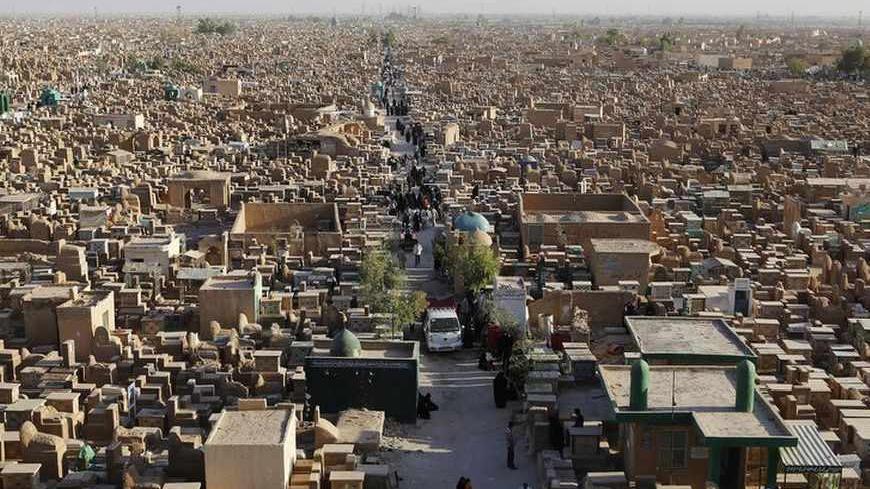 People visit the "Valley of Peace" cemetery during the first day of the Eid al-Fitr in Najaf, 160 km (100 miles) south of Baghdad, August 9, 2013. Muslims around the world celebrate Eid al-fitr to mark the end of Ramadan, the holiest month in the Islamic calendar.  REUTERS/Ahmad Mousa  (IRAQ - Tags: RELIGION) - RTX12ESW