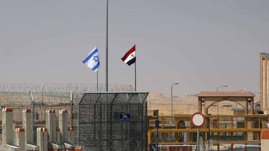 An Israeli flag (L) flutters next to an Egyptian one at the Nitzana crossing, along Israel's border with Egypt's Sinai desert, as seen from the Israeli side August 20, 2013. Egypt began three days of official mourning for 25 policemen killed on Monday by suspected Islamist militants in the Sinai near the desert border with Israel. REUTERS/Ronen Zvulun (ISRAEL - Tags: POLITICS) - RTX12RGM