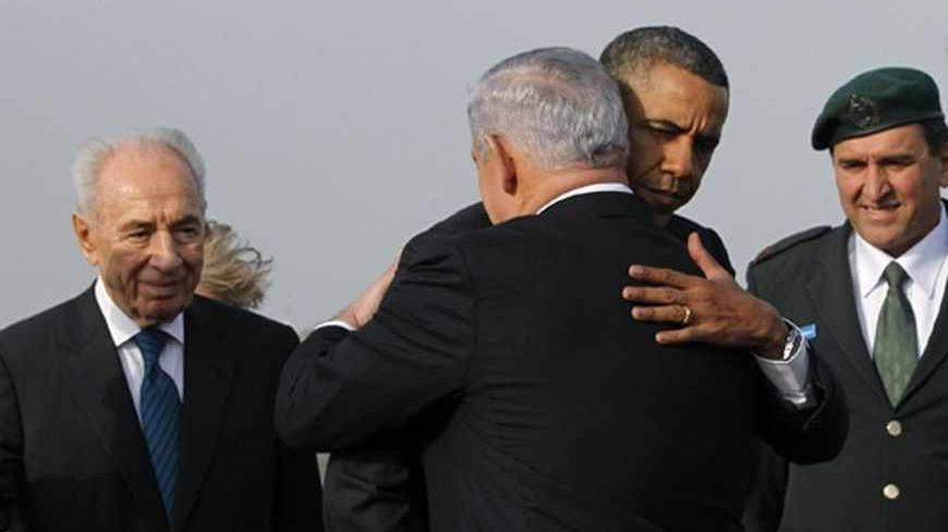 U.S. President Barack Obama hugs Israeli Prime Minister Benjamin Netanyahu as President Shimon Peres (L) watches on, before Obama's departure from Tel Aviv International Airport, March 22, 2013.   REUTERS/Jason Reed   (ISRAEL - Tags: POLITICS) - RTR3FBUO