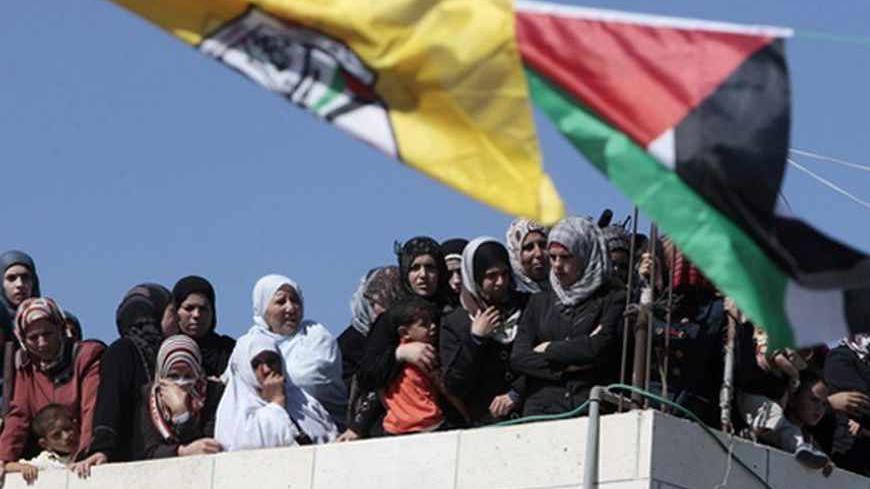 Palestinian women watch the funeral of Moataz Sharawneh in the West Bank village of Dura, near Hebron July 2, 2013. Israeli soldiers shot dead Sharawneh during a confrontation in the occupied West Bank on Tuesday, Palestinian officials said. An Israeli military spokeswoman said Palestinians threw rocks at soldiers who were on routine duties in Dura. REUTERS/Ammar Awad (WEST BANK - Tags: POLITICS CIVIL UNREST) - RTX11A6N