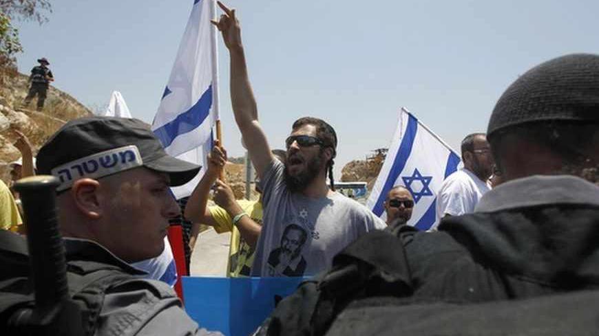 A Jewish ultranationalist shouts slogans in front of Israeli police during a rally in Nazareth, Israel's largest Arab town, calling to draft Israeli Arabs July 15, 2012. Military service is a rite of passage for most Israelis, who view the army as a core element of national identity. That is where the problem starts for many Arabs, who associate more closely with the Palestinians and feel alienated in a country created in 1948 that defines itself as a Jewish state. REUTERS/Baz Ratner (ISRAEL - Tags: POLITIC