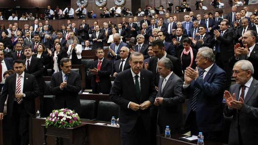Turkey's Prime Minister Tayyip Erdogan (C) leaves his seat to address members of parliament from his ruling AK Party (AKP) during a meeting at the Turkish parliament in Ankara June 11, 2013. Erdogan called on protesters to withdraw from central Istanbul's Gezi Park on Tuesday and said the wave of anti-government demonstrations was part of a deliberate attempt to damage Turkey's image and economy. REUTERS/Umit Bektas (TURKEY - Tags: POLITICS CIVIL UNREST) - RTX10JH8