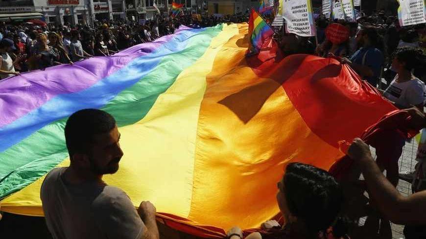 Gay rights activists carry a rainbow flag during a protest at Taksim Square in Istanbul June 23, 2013.  REUTERS/Marko Djurica (TURKEY - Tags: CIVIL UNREST SOCIETY) - RTX10Y6Y