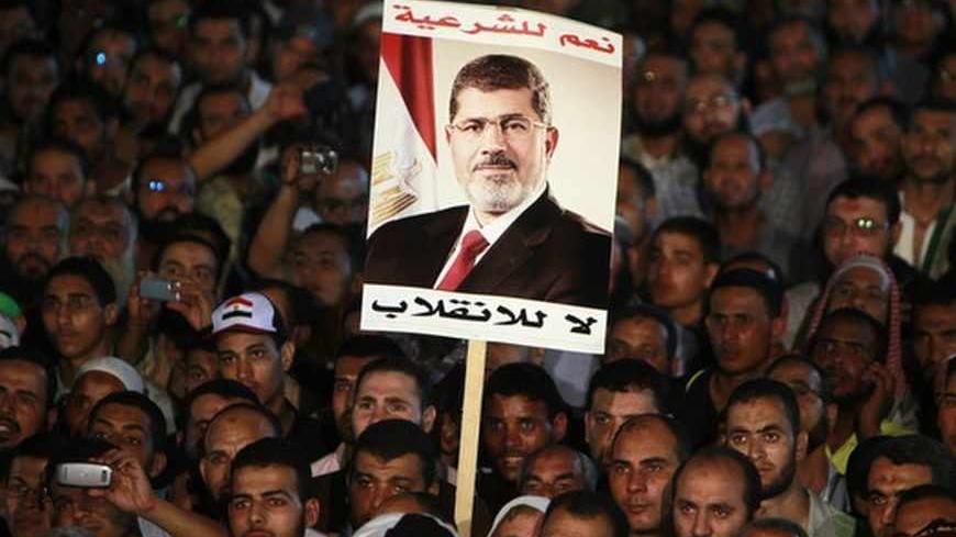 Supporters of deposed Egyptian President Mohamed Mursi hold up a poster of Mursi during a protest at the Rabaa al-Adawiya square where they are camping, in Cairo, August 6, 2013. The chances for a negotiated end to Egypt's political crisis looked to have hit the rocks on Tuesday with the army-installed government reportedly ready to declare that foreign mediation efforts had failed. It would also declare that Muslim Brotherhood protests against the army's overthrow of Mursi were non-peaceful - a signal that