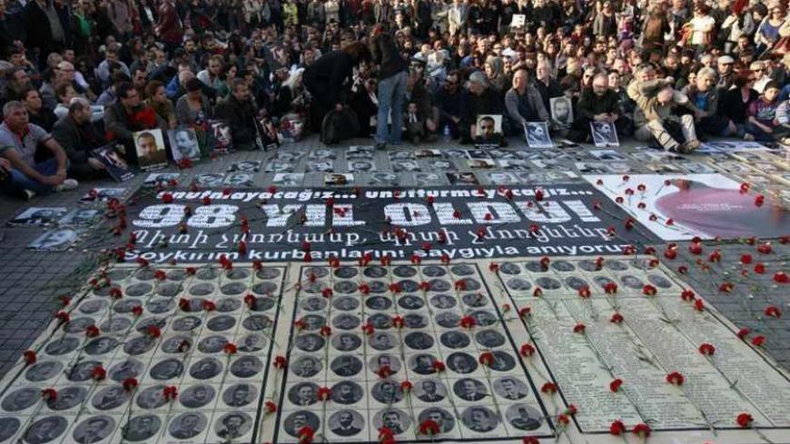 Human rights activists sit behind pictures of Armenian victims at Taksim square in central Istanbul April 24, 2013, during a demonstration to commemorate the 1915 mass killing of Armenians in the Ottoman Empire. REUTERS/Osman Orsal (TURKEY - Tags: ANNIVERSARY POLITICS CIVIL UNREST) - RTXYYD8