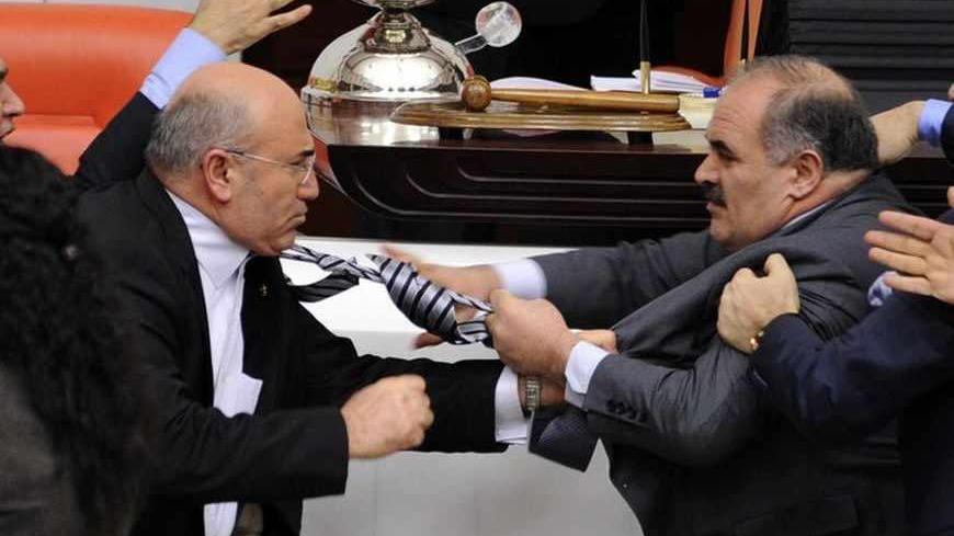 Turkey's ruling AK Party (AKP) lawmaker Muhittin Aksak (R) and main opposition Republican People's Party (CHP) lawmaker Mahmut Tanal (L) scuffle during a debate at the parliament in Ankara late February 8, 2012. REUTERS/Stringer (TURKEY - Tags: POLITICS CIVIL UNREST) - RTR2XIJE