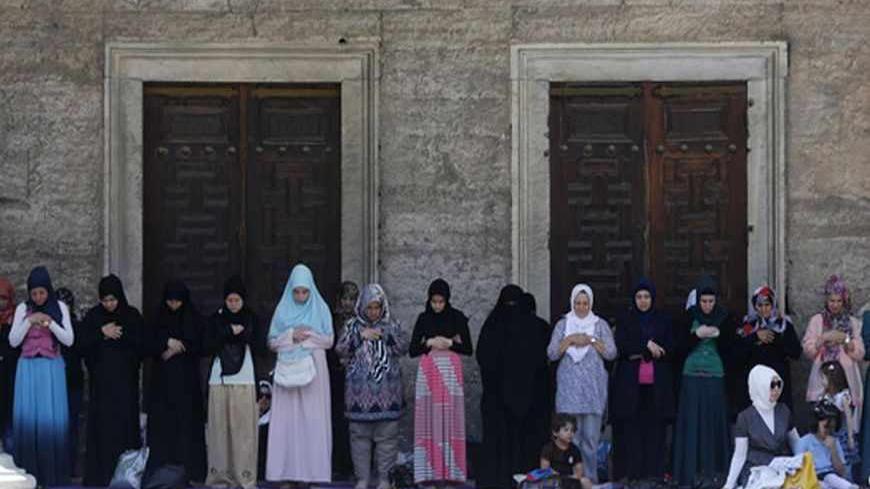 Women attend Friday prayers during the Muslim holy month of Ramadan at the courtyard of Sultanahmet mosque, also known as the Blue Mosque, in Istanbul July 12, 2013. REUTERS/Murad Sezer (TURKEY - Tags: RELIGION) - RTX11KYO