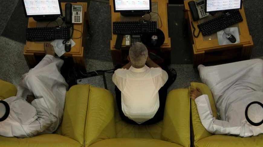 Traders monitor stock information at the Emirates Securities Market in Abu Dhabi December 12, 2010. REUTERS/Fadi Al-Assaad (UNITED ARAB EMIRATES - Tags: BUSINESS) - RTXVNM8