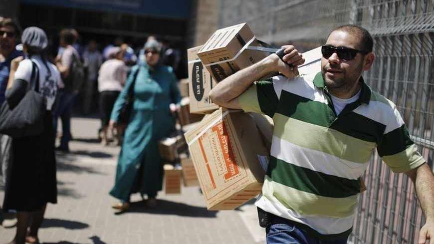A man carries gas masks kits which he collected from a distribution centre in Jerusalem August 29, 2013. Israel ordered a small-scale mobilisation of reservists on Wednesday and strengthened its missile defences as precautions against possible Syrian attack should Western powers carry out threatened strikes on Syria. Many Israelis continued to queue up for gas masks at distribution centres on Thursday. REUTERS/Amir Cohen (JERUSALEM - Tags: POLITICS MILITARY CIVIL UNREST) - RTX1302E