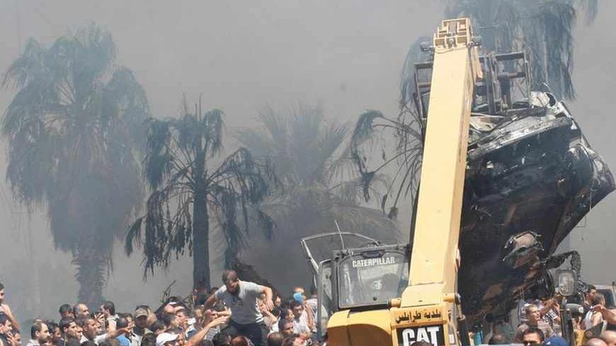 A crane removes burnt cars from outside one of two mosques hit by explosions in Lebanon's northern city of Tripoli, August 23, 2013. Twin explosions outside two mosques killed at least 27 people and wounded hundreds in apparently coordinated attacks in the northern Lebanese city of Tripoli on Friday, a senior health official and witnesses said. REUTERS/Sobhi Al-Sharif (LEBANON - Tags: POLITICS CIVIL UNREST) - RTX12U8F