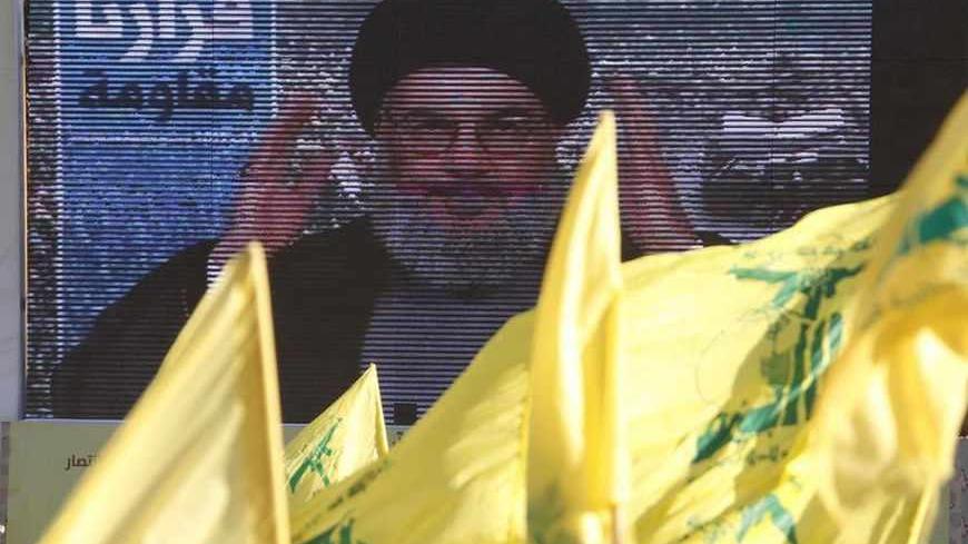 Lebanon's Hezbollah leader Sayyed Hassan Nasrallah addresses his supporters via a screen during a rally on the 7th anniversary of the end of Hezbollah's 2006 war with Israel, in Aita al-Shaab village in southern Lebanon, August 16, 2013. Nasrallah renewed his commitment on Friday to the battle in Syria, where the Shi'ite militant group has been fighting alongside President Bashar al-Assad's forces, saying he was ready to go himself if needed. REUTERS/Ali Hashisho    (LEBANON - Tags: POLITICS CIVIL UNREST AN