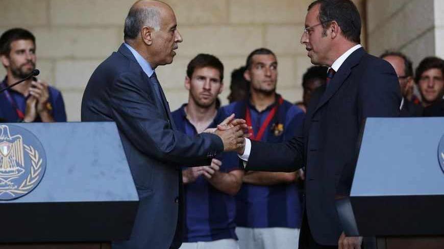 Barcelona President Sandro Rosell (R) and Palestinian Football Association President Jibril Rajoub shake hands after addressing members of the media at the start of a visit by the soccer team at the Palestinian President's office in the West Bank town of Bethlehem August 3, 2013. Barcelona is on a two-day "Peace Tour" in the region, which will include conducting soccer clinics for young people. REUTERS/Mohamad Torokman  (WEST BANK - Tags: SPORT SOCCER) - RTX129MC