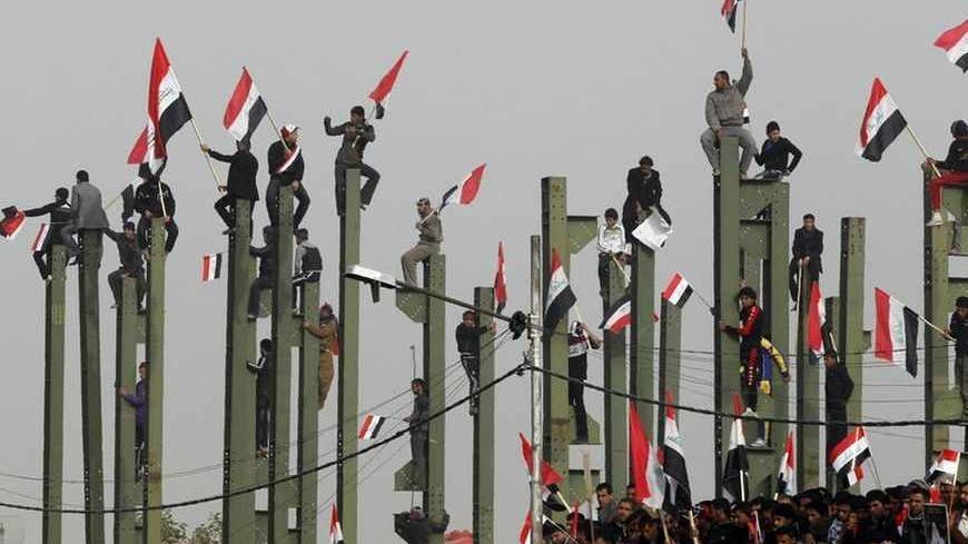 Supporters of anti-U.S. Shi'ite cleric Moqtada al-Sadr wave Iraqi flags during a rally in Baghdad, February 9, 2012.  REUTERS/Mohammed Ameen (IRAQ - Tags: CIVIL UNREST POLITICS TPX IMAGES OF THE DAY) - RTR2XJEL