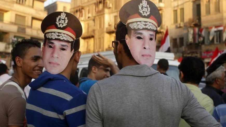 Protesters wear masks depicting army chief Abdel-Fattah El-Sisi as they gather for a mass protest to support the army in Tahrir square in Cairo, July 26, 2013. The Egyptian army is detaining Mursi over accusations of kidnapping, killing soldiers and other charges, the state news agency said on Friday.  REUTERS/Asmaa Waguih (EGYPT - Tags: POLITICS CIVIL UNREST) - RTX12084