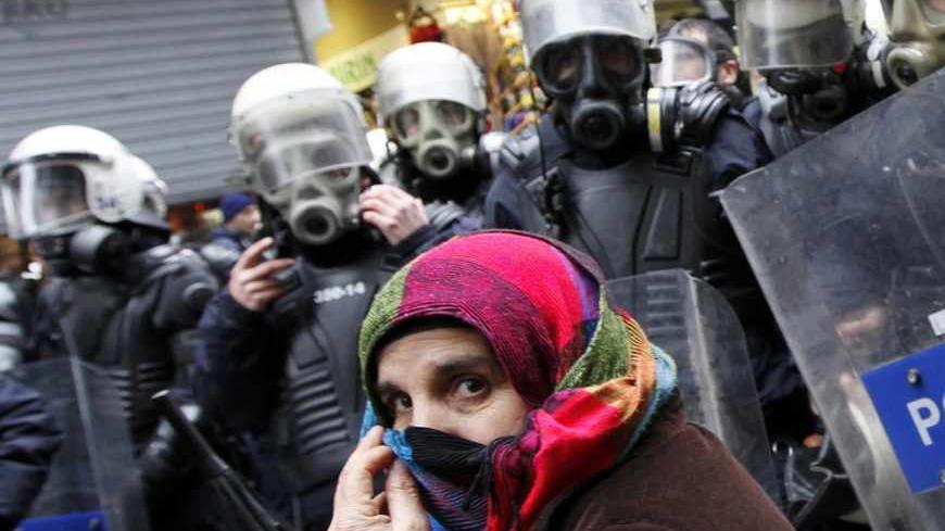 A pro-Kurdish demonstrator covers her face as riot police prevent protestors from marching, at Taksim square in central Istanbul February 15, 2012. Supporters of the pro-Kurdish Peace and Democracy Party (BDP) held a protest to mark the 13th anniversary of the capture of Kurdistan Workers' Party (PKK) leader Abdullah Ocalan. REUTERS/Murad Sezer (TURKEY - Tags: POLITICS CIVIL UNREST CRIME LAW) - RTR2XWBQ