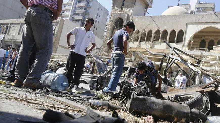 Relatives of car bomb victims inspect the damaged cars at the bomb explosion site in front of al-Salam mosque in the port city of Tripoli in northern Lebanon August 24, 2013. Bombs hit two mosques in the northern Lebanese city of Tripoli on Friday, killing at least 42 people and wounding hundreds, intensifying sectarian strife that has spilled over from the civil war in neighbouring Syria. REUTERS/Jamal Saidi (LEBANON - Tags: CIVIL UNREST POLITICS) - RTX12UWT