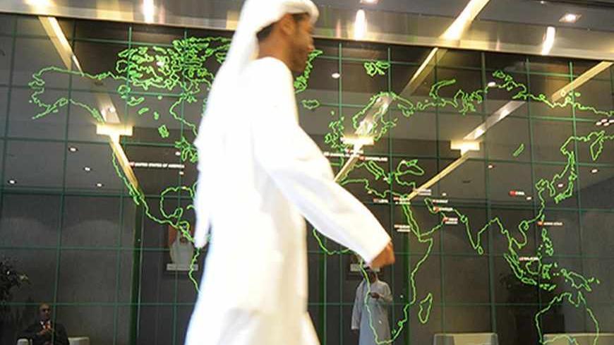 An employee walks past a screen displaying the worldwide locations of the National Bank of Abu Dhabi, at the bank's headquarters in Abu Dhabi, April 3, 2013. The National Bank of Abu Dhabi named the banker who led Australia and New Zealand Banking Group's push into Asia as its chief executive on Wednesday, as it expands abroad from its saturated local market. REUTERS/Ben Job (UNITED ARAB EMIRATES - Tags: BUSINESS) - RTXY6VB