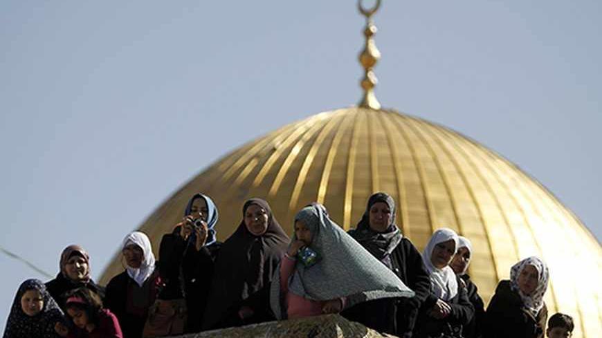 The Dome of the Rock, on the compound known to Muslims as al-Haram al-Sharif and to Jews as Temple Mount, in Jerusalem's Old City, is seen in the background as Palestinian onlookers survey a protest calling for the release of Palestinian prisoners held in Israeli jails February 8, 2013. REUTERS/Ammar Awad (JERUSALEM - Tags: RELIGION POLITICS) - RTR3DI1Z