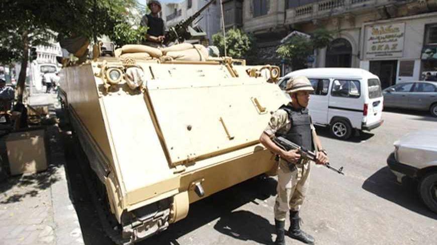 A soldier stands next to an armoured personnel carrier (APC) near the al-Fath mosque on Ramses Square in Cairo, September 11, 2013. REUTERS/Mohamed Abd El Ghany (EGYPT - Tags: POLITICS CIVIL UNREST MILITARY) - RTX13HEG