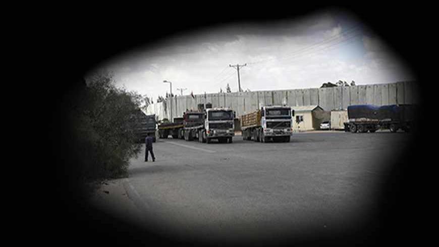 Trucks transporting construction materials are seen through a crack in a police post after entering the Gaza Strip through the Kerem Shalom crossing September 22, 2013. Israel began allowing construction material for private projects into the Gaza Strip on Sunday for the first time in six years, in response to a request from Palestinian President Mahmoud Abbas, an Israeli defence official said. REUTERS/Ibraheem Abu Mustafa (GAZA - Tags: POLITICS BUSINESS CONSTRUCTION REAL ESTATE TPX IMAGES OF THE DAY) - RTX