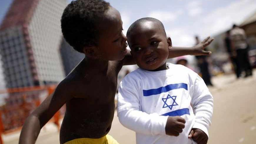 Children of migrant workers play on a beach in Tel Aviv, on Israel's Independence Day, marking the 65th anniversary of the creation of the state, April 16, 2013. REUTERS/Amir Cohen (ISRAEL - Tags: SOCIETY IMMIGRATION ANNIVERSARY) - RTXYNUK