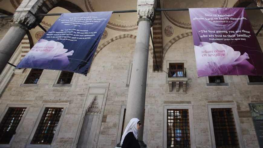 A woman walks at the courtyard of the Ottoman-era Sultanahmet mosque, also known as the Blue Mosque, in Istanbul April 26, 2013. The banners depicting the hadiths, sayings of Prophet Mohammad, hang on the occasion of the celebration of the Prophet's birthday. Scholars around the Muslim world were alarmed five years ago by news reports that Turkey planned a new, possibly heretical compilation of the Prophet's sayings that might scrap those it thought were out of date. Turkish religious leaders and theologian