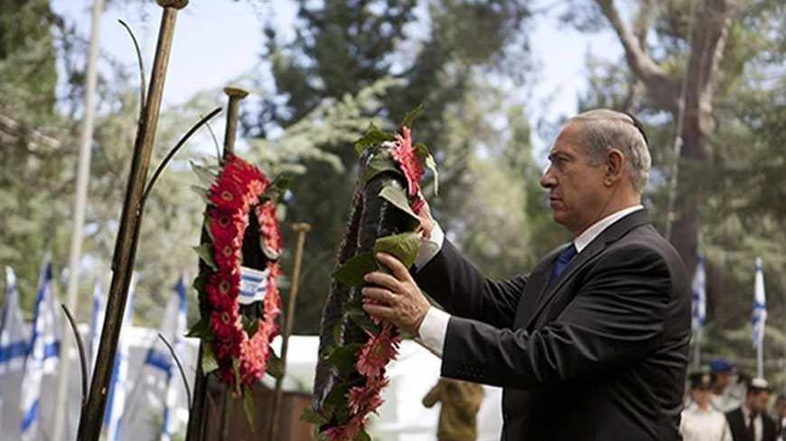 Israeli Prime Minister Benjamin Netanyahu lays a wreath during a memorial ceremony for Israeli soldiers killed in the 1973 Middle East War at Mount Herzl Military Cemetery in Jerusalem September 15, 2013. Netanyahu gave a guarded response on Sunday to a U.S.-Russian deal on Syria's chemical weapons, saying it would be judged on whether it achieved "complete destruction" of the arsenal. REUTERS/Lior Mizrahi/Pool (JERUSALEM - Tags: POLITICS ANNIVERSARY) - RTX13LZJ