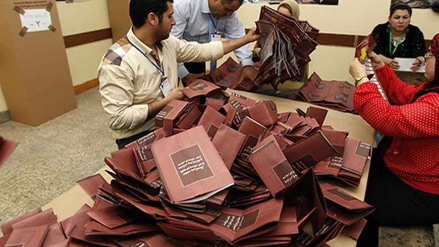 Employees of Independent High Electoral Commission (IHEC) count ballots during regional parliamentary elections after the closing of a polling station in Arbil, capital of the autonomous Kurdistan region, about 350 km (217 miles) north of Baghdad, September 21, 2013. Iraqi Kurds voted on Saturday for a new parliament that analysts said was poised to lead the oil-producing region further down the road to greater autonomy from Baghdad.  REUTERS/Thaier Al-Sudani (IRAQ - Tags: ELECTIONS POLITICS BUSINESS) - RTX
