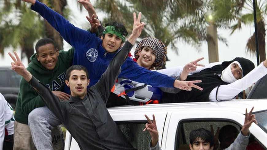 Youths gesture from a vehicle during celebrations of Kuwait's National Day February 25, 2012. REUTERS/Stephanie McGehee (KUWAIT - Tags: POLITICS) - RTR2YF3R