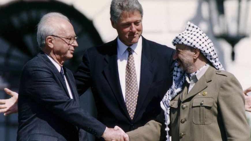 PLO Chairman Yasser Arafat (R) shake hands with Israeli Prime Minister Yitzhak Rabin (L), as U.S. President Bill Clinton stands between them, after the signing of the Israeli-PLO peace accord, at the White House in Washington September 13, 1993. REUTERS/Gary Hershorn (UNITED STATES - Tags: POLITICS) - RTX13K52