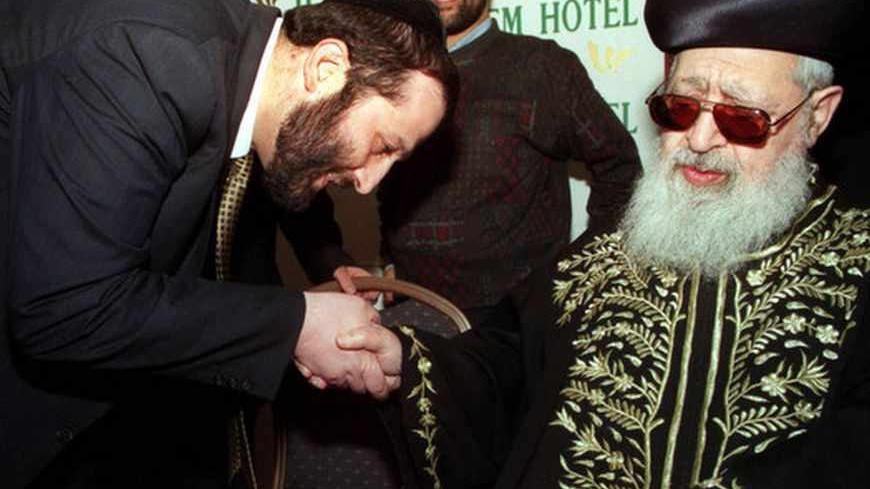 Aryeh Deri, (L), a political kingmaker and head of the ultra-Orthodox Shas party, kisses the hand of the party's spiritual leader, Rabbi Ovadia Yosef, at a women's conference March 16, a day before an Israeli court is due to rule in his fraud and bribery trial. Israeli Police are preparing for large protests by Shas supporters if the verdict goes against Deri, who has been on trial since 1993 on charges he illegally channelled government funds to Shas-affiliated organisations and pocketed some of the money 