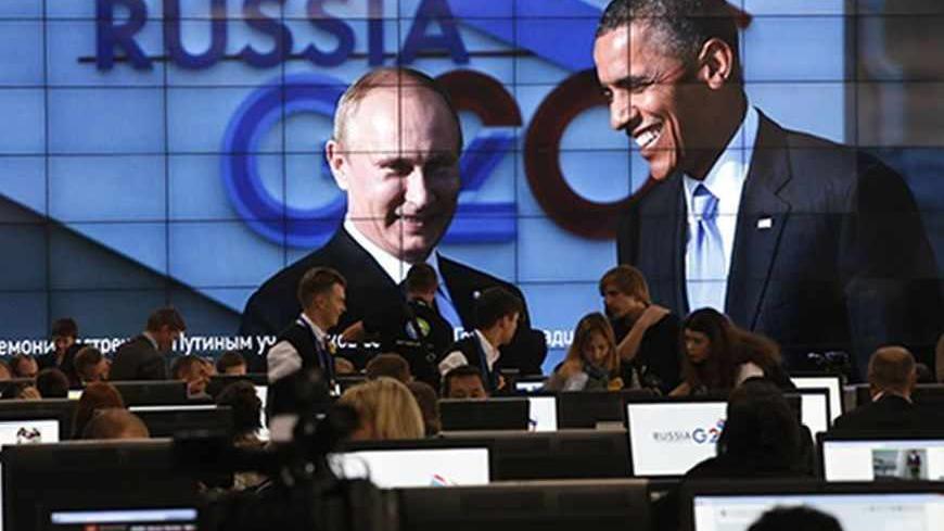 Russian President Vladimir Putin (L) and U.S. President Barack Obama are pictured on a video screen installed in the press centre of the G20 Summit in Strelna near St. Petersburg, September 5, 2013.           REUTERS/Grigory Dukor (RUSSIA  - Tags: POLITICS)   - RTX138DW