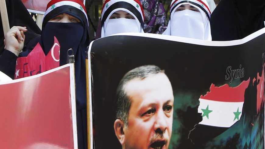Syrian opposition demonstrators living in Jordan hold a poster of Turkish Prime Minister Tayyip Erdogan during a rally in front of the Turkish embassy in Amman June 26, 2011, in support of Turkey's tough stance against President Bashar al-Assad.  REUTERS/Ali Jarekji (JORDAN - Tags: POLITICS) - RTR2O4DU