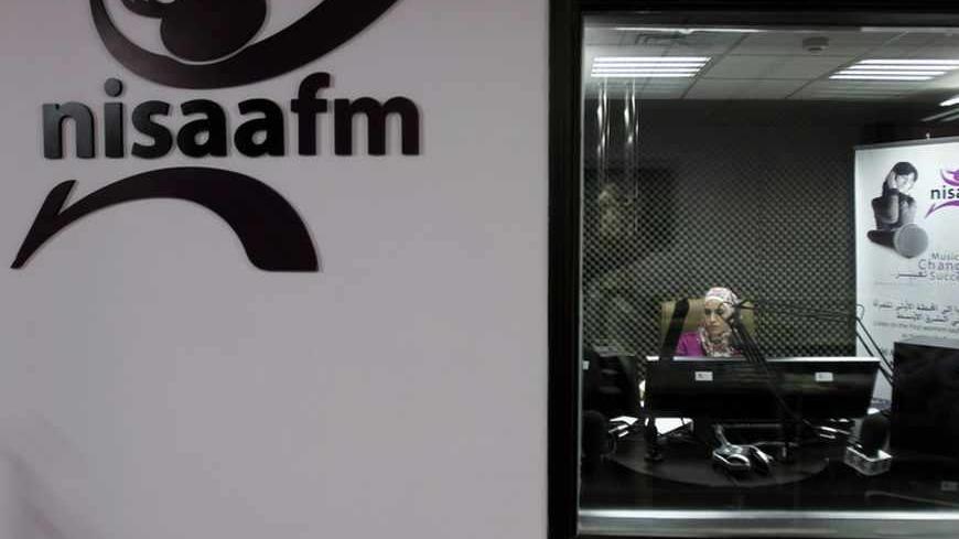 A radio broadcaster sits in the sound booth at NISAA FM radio station in the West Bank city of Ramallah July 9, 2012. Looking to spread the good word, NISAA FM radio station took to the airwaves in 2010, set up by and for women. It highlights local success stories about anything from female-led investment groups to refugee camp microfinance projects. Picture taken July 9, 2012. To match story PALESTINIAN-BUSINESS/WOMEN  REUTERS/Mohamad Torokman (WEST BANK - Tags: BUSINESS MEDIA) - RTR34TV0