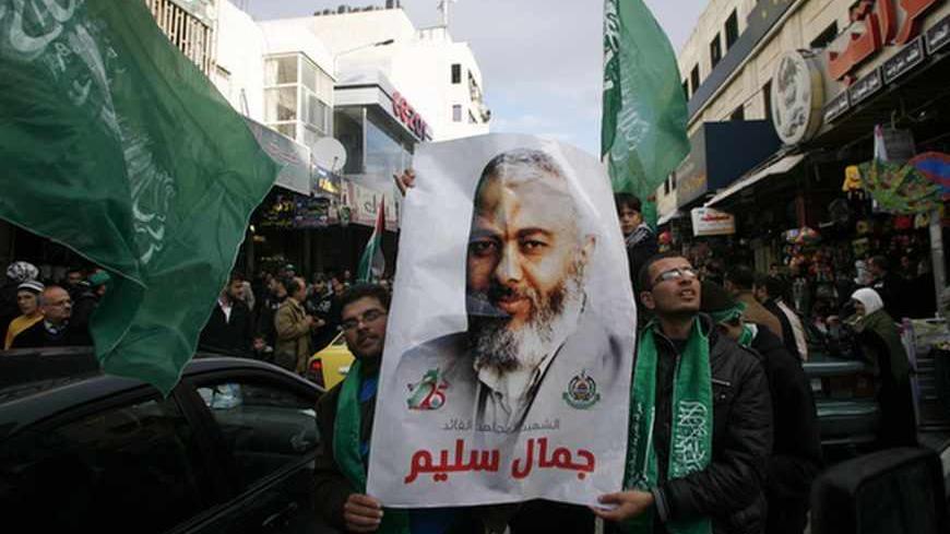 Palestinians hold a placard depicting senior Hamas leader Ismail Haniyeh during a rally in the West Bank city of Nablus, marking the 25th anniversary of the founding of Hamas December 13, 2012. It was the first rally Western-backed Palestinian President Mahmoud Abbas allowed to take place in the West Bank since 2007, when his Islamist rivals Hamas seized control of the Gaza Strip. REUTERS/Muammar Awad (WEST BANK - Tags: POLITICS ANNIVERSARY) - RTR3BJHE
