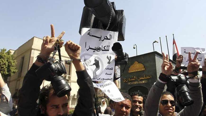 Photographers hold up placards as they protest against government policies and the Muslim Brotherhood's treatment towards photographers, in Cairo March 19, 2013. REUTERS/Khaled Elfiqi/Egyptian Photo Journalistic Society/Pool (EGYPT - Tags: POLITICS MEDIA CIVIL UNREST) - RTR3F6WN