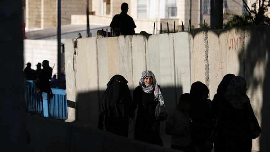 Palestinian women cross at an Israeli checkpoint in the West Bank town of Bethlehem, during the holy month of Ramadan July 26, 2013. REUTERS/Baz Ratner (WEST BANK - Tags: POLITICS RELIGION SOCIETY) - RTX11ZWA