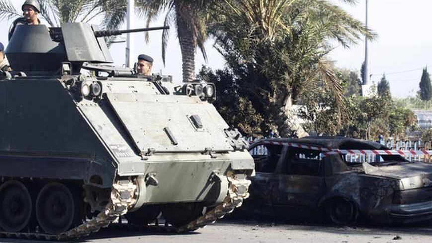 A Lebanese army armoured personnel carrier is seen after re-deployment in the port city of Tripoli in northern Lebanon August 24, 2013. Bombs hit two mosques in the northern Lebanese city of Tripoli on Friday, killing at least 42 people and wounding hundreds, intensifying sectarian strife that has spilled over from the civil war in neighbouring Syria. REUTERS/Rayan al-Turk  (LEBANON - Tags: CIVIL UNREST POLITICS) - RTX12V0X