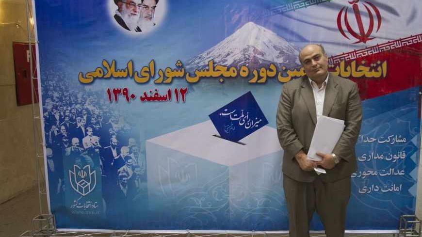 Iranian-Jewish minority Member of Parliament, Siamak Meresedgh, poses for a photograph in front of a banner for the 2012 parliamentary elections, after he registered as a candidate at the Interior Ministry building in Tehran December 25, 2011. Candidates began registering on Saturday for Iran's parliamentary elections in March, the first litmus test of the clerical establishment's popularity since the 2009 disputed presidential vote. REUTERS/Morteza Nikoubazl (IRAN - Tags: POLITICS ELECTIONS) - RTR2VMNV