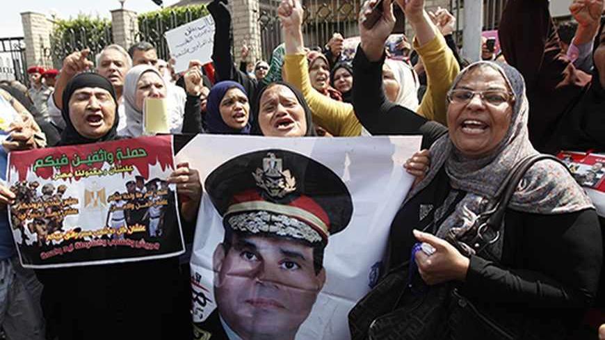 Mourners hold a poster of Army Chief General Abdel Fattah al-Sisi during the military funeral service of police General Nabil Farag, who was killed on Thursday in Kerdasa, in Cairo's Nasr City district September 20, 2013. Egyptian security forces were hunting for supporters of deposed President Mohamed Mursi of the Muslim Brotherhood on Friday after retaking control of the town near Cairo in a crackdown on Islamists. On Thursday, army and police forces stormed Kerdasa where Islamist sympathies run deep and 
