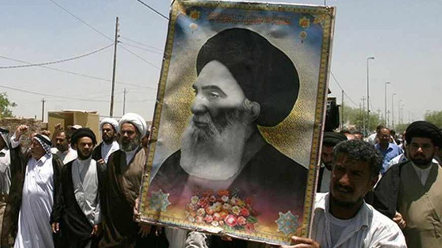 Iraqis carry a poster of top Shi'ite cleric Grand Ayatollah Ali al-Sistani during a demonstration in Najaf, 160 km (100 miles) south of Baghdad June 13, 2007. Dozens of residents took to the streets in Najaf protesting the latest bomb attack in Samarra's Golden Mosque Shi'ite shrine.     REUTERS/Ali Abu Shish    (IRAQ) - RTR1QQY3