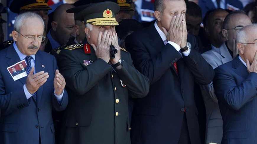(L-R) Turkey's main opposition Republican People's Party Leader Kemal Kilicdaroglu, Chief of Staff General Necdet Ozel, Prime Minister Tayyip Erdogan and Chairman of the Parliament Cemil Cicek pray as they attend an official farewell ceremony for fallen Turkish pilots, Captain Gokhan Ertan and Lieutenant Hasan Huseyin, at the 7th Jet Main Air Base in the eastern Turkish city of Malatya July 6, 2012. Turkish Prime Minister Tayyip Erdogan and top military officials attend the funeral of the two pilots of the 