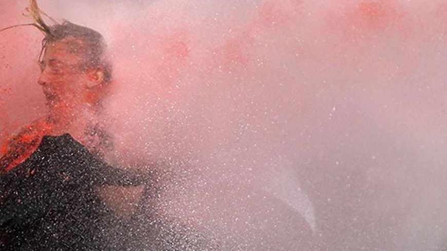 A woman is attacked by water cannon during protests in Kizilay square in central Ankara, June 16, 2013. The unrest, in which police fired teargas and water cannon at stone-throwing protesters night after night in cities including Istanbul and Ankara, left four people dead and about 5,000 injured, according to the Turkish Medical Association.  REUTERS/Dado Ruvic (TURKEY - Tags: POLITICS CIVIL UNREST TPX IMAGES OF THE DAY) - RTX10PPE